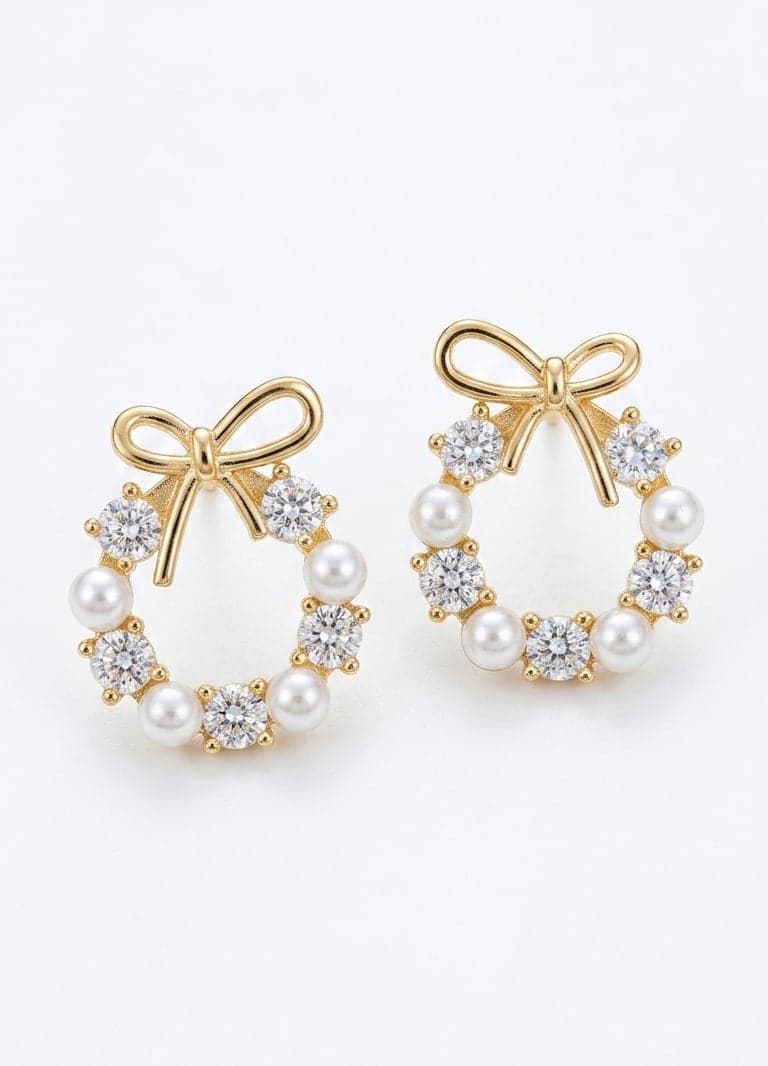 Earrings with a gold-plated brass base, zircon stones, and a round plastic pearl-studded bow detail
