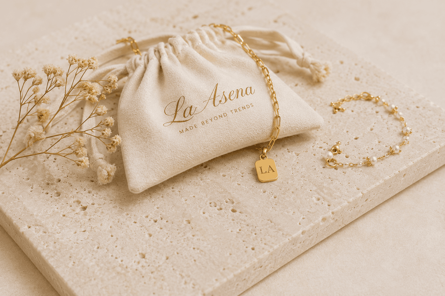 Golden La Asena jewelry arranged on warm stone